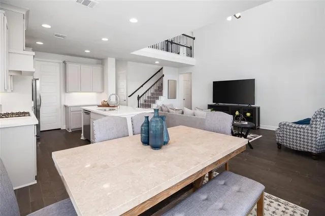 a living room with stainless steel appliances furniture a rug and a flat screen tv