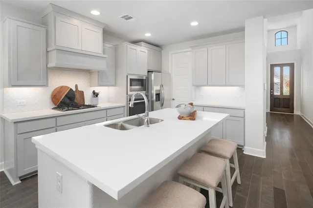 a kitchen with kitchen island a stove a sink and a refrigerator