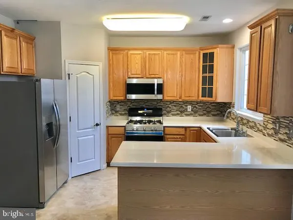 a kitchen with a refrigerator a stove a sink and a microwave