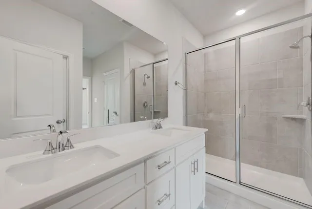 a bathroom with a sink double vanity and a shower