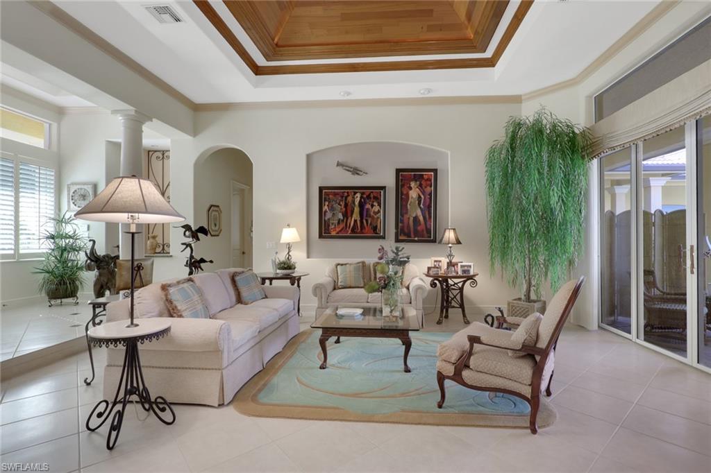 435 Terracina Way Naples, FL 34119 - Photo 5 of 50 Tiled living area featuring crown molding, arched walkways, and a raised ceiling