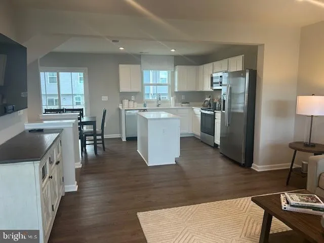 a kitchen with a table chairs refrigerator and cabinets