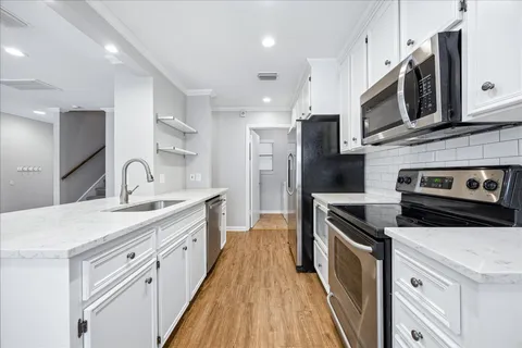 a kitchen with stainless steel appliances a sink stove and refrigerator