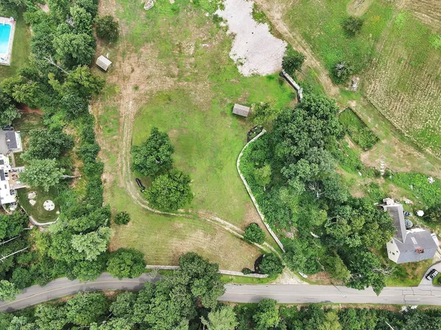 an aerial view of a residential houses with yard