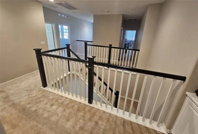 a view of a hallway with wooden floor and a bathroom