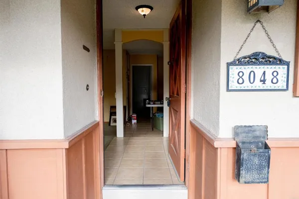 a view of a hallway with a door and furniture