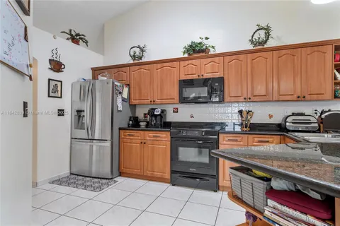 a kitchen with stainless steel appliances granite countertop a refrigerator and a stove top oven