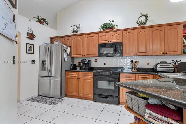 a kitchen with stainless steel appliances granite countertop a refrigerator and a stove top oven