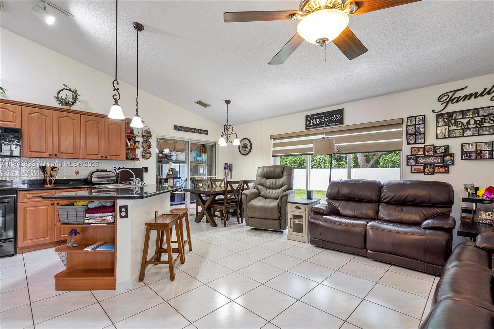 1841 Southwest 124th Way Miramar, FL 33027 - Photo 14 of 34 a living room with furniture kitchen view and a chandelier
