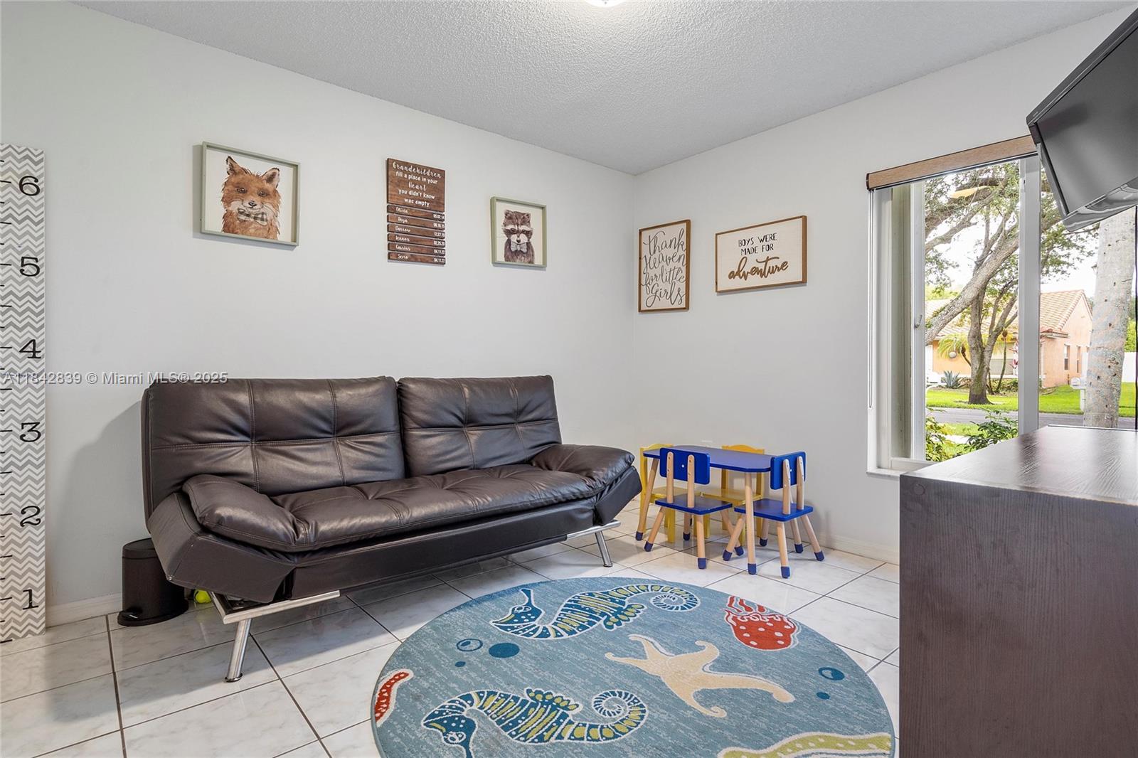 1841 Southwest 124th Way Miramar, FL 33027 - Photo 17 of 34 a living room with furniture and a book shelf