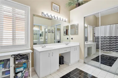 a spacious bathroom with a shower a sink and a large mirror
