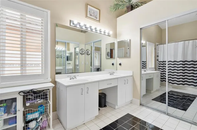a spacious bathroom with a shower a sink and a large mirror
