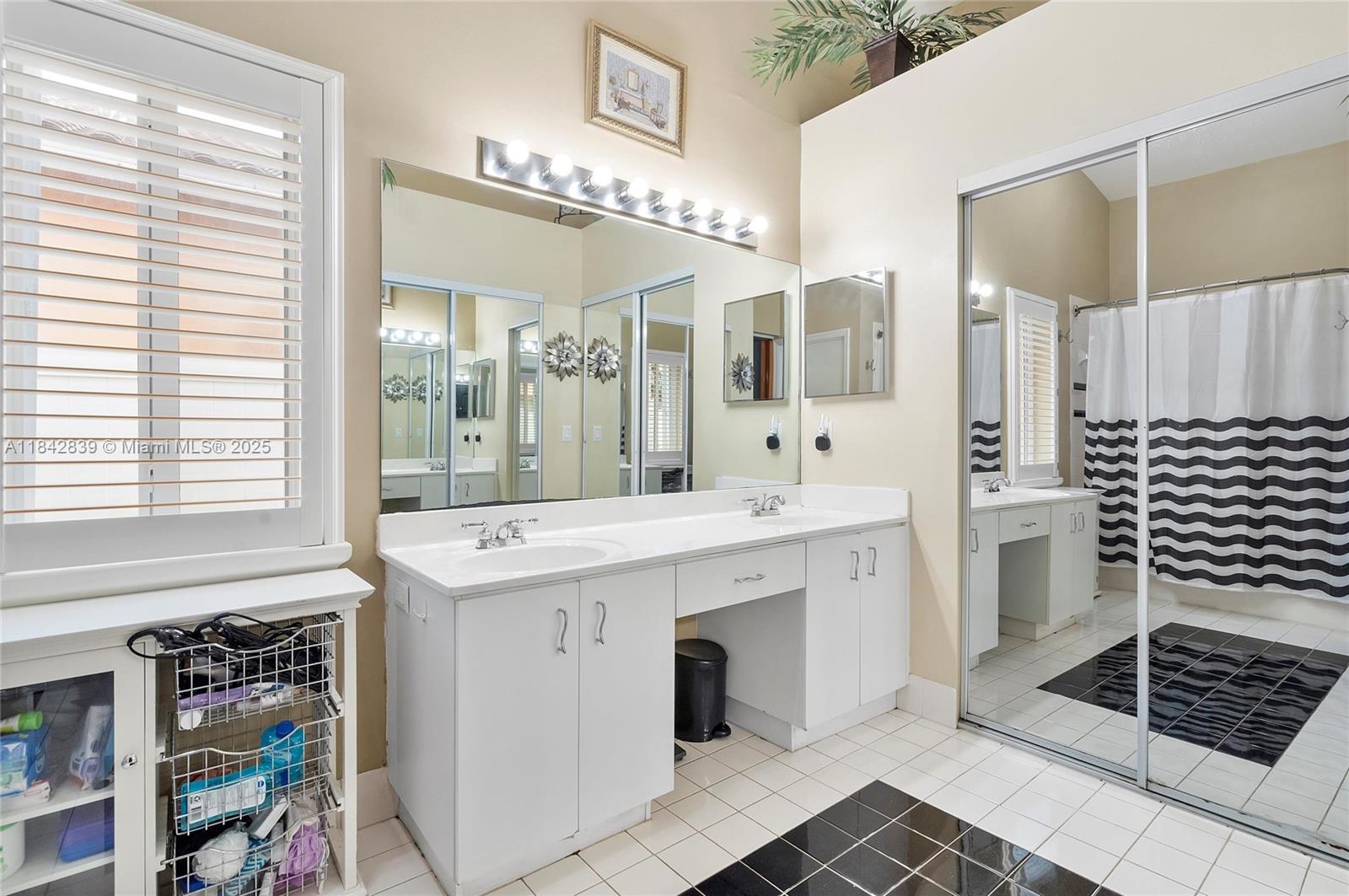 1841 Southwest 124th Way Miramar, FL 33027 - Photo 23 of 34 a spacious bathroom with a shower a sink and a large mirror