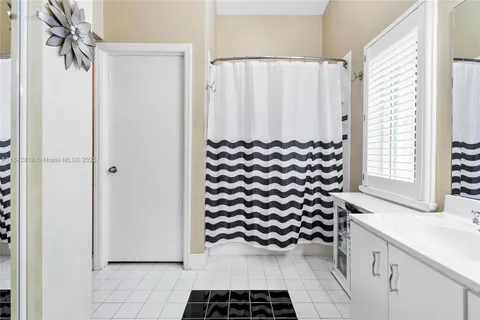 a bathroom with a sink a mirror and a shower curtain