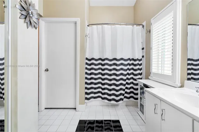 a bathroom with a sink a mirror and a shower curtain