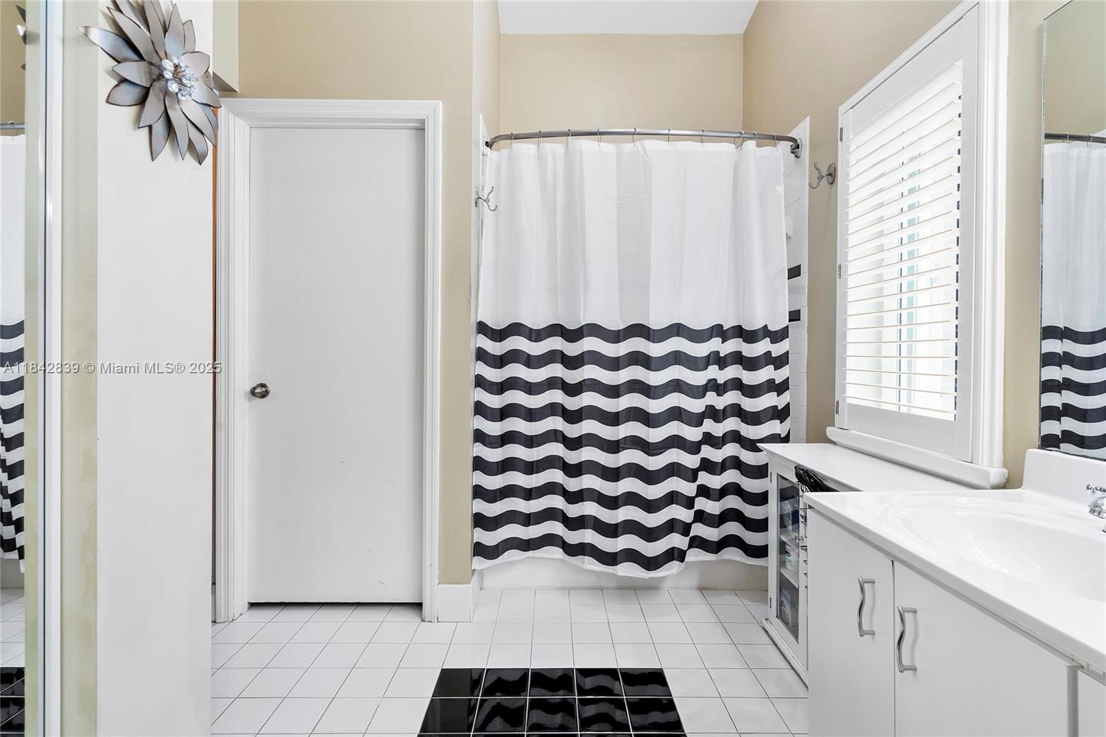 1841 Southwest 124th Way Miramar, FL 33027 - Photo 26 of 34 a bathroom with a sink a mirror and a shower curtain