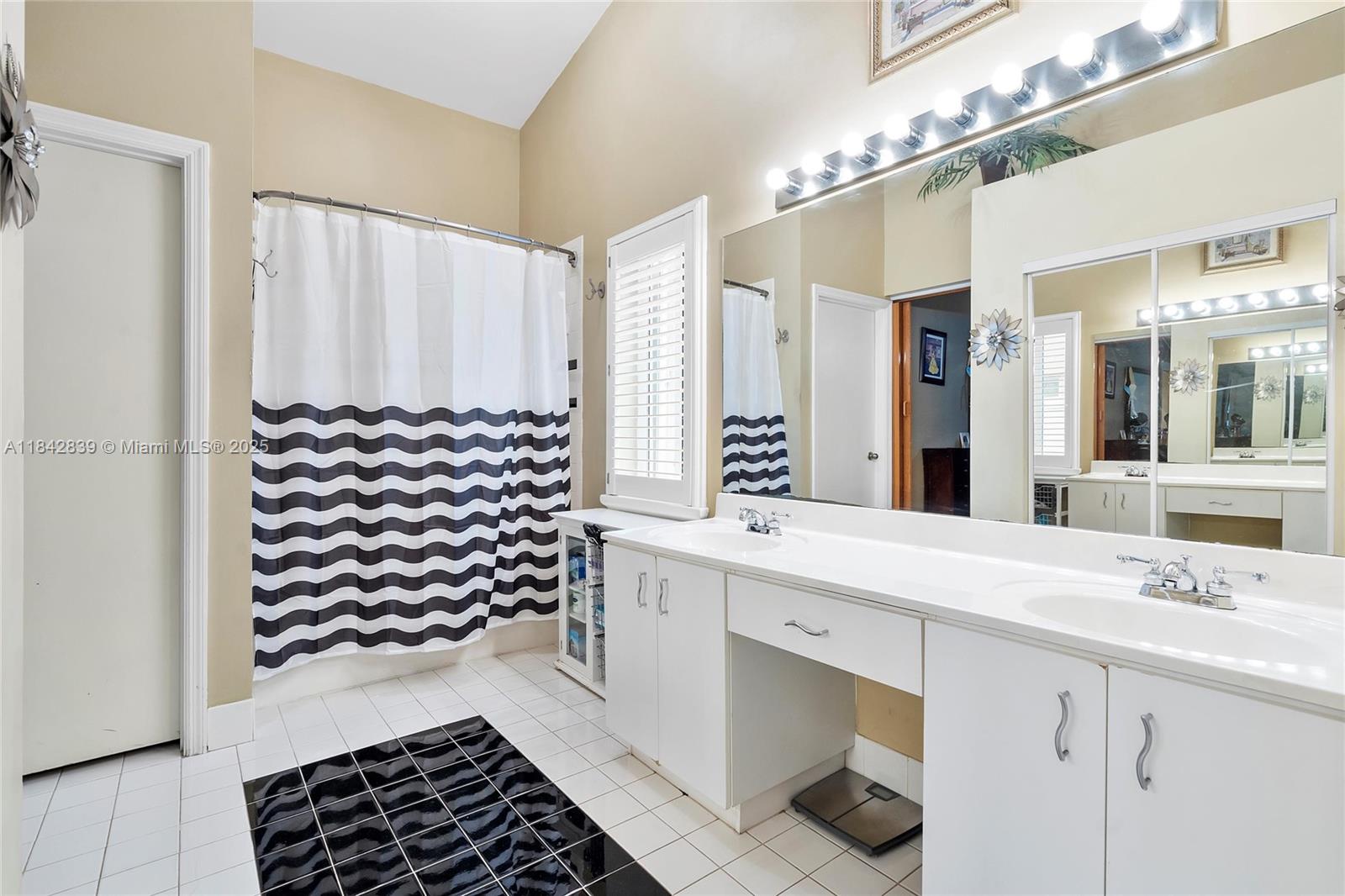 1841 Southwest 124th Way Miramar, FL 33027 - Photo 27 of 34 a bathroom with a sink a mirror and a shower