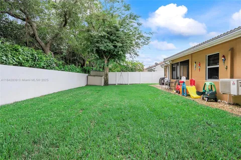 a view of a backyard with table and chairs and a large tree