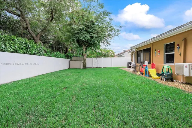 a view of a backyard with table and chairs and a large tree
