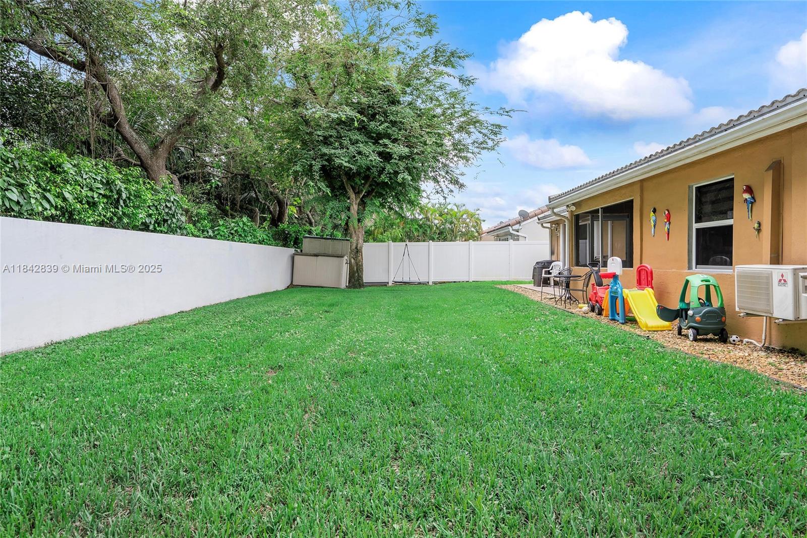 1841 Southwest 124th Way Miramar, FL 33027 - Photo 33 of 34 a view of a backyard with table and chairs and a large tree