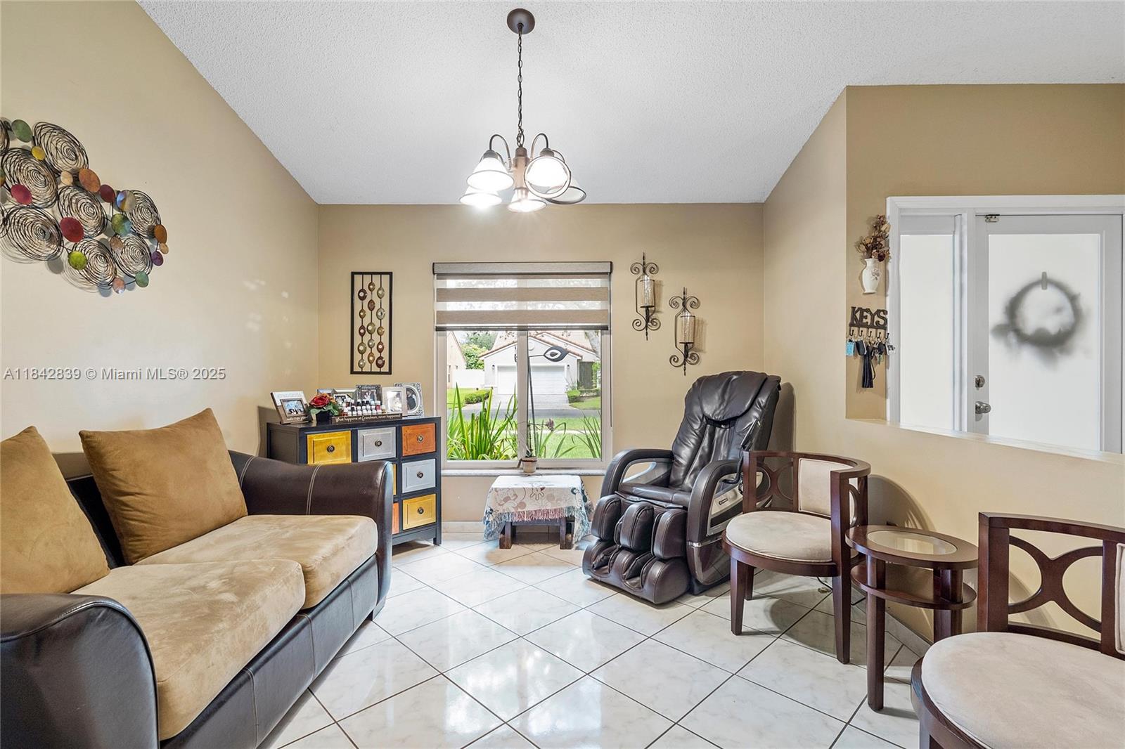 1841 Southwest 124th Way Miramar, FL 33027 - Photo 7 of 34 a living room with furniture chandelier and a large window