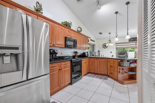 a kitchen with stainless steel appliances granite countertop a refrigerator sink and cabinets