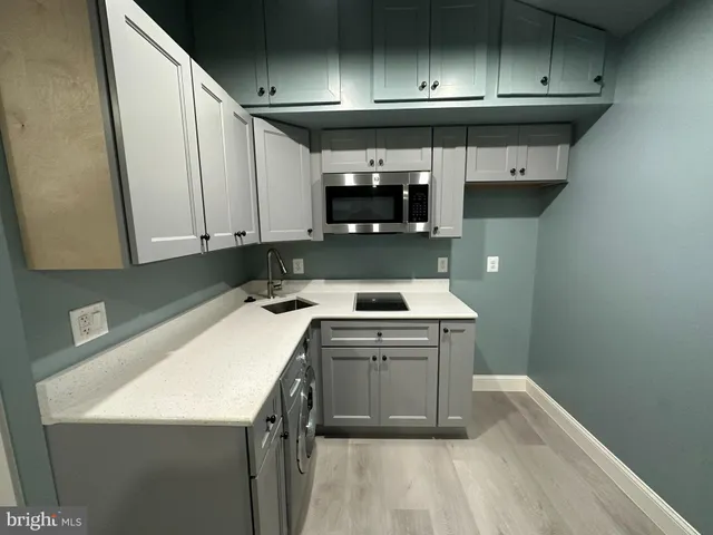 a kitchen with a sink a stove and cabinets