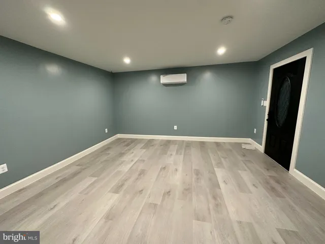 an empty room with wooden floor and entrance