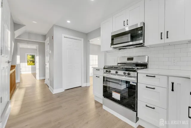 a kitchen with stainless steel appliances a stove a microwave and sink