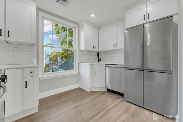 a kitchen with white cabinets and white stainless steel appliances