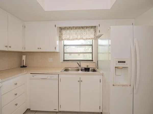 a kitchen with white cabinets and white appliances