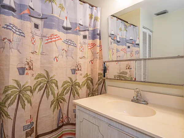 a bathroom with a sink and mirror with bathtub