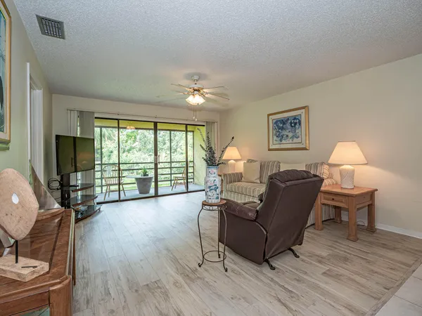a living room with furniture a flat screen tv and a large window