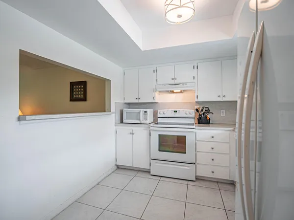 a kitchen with white cabinets and white appliances