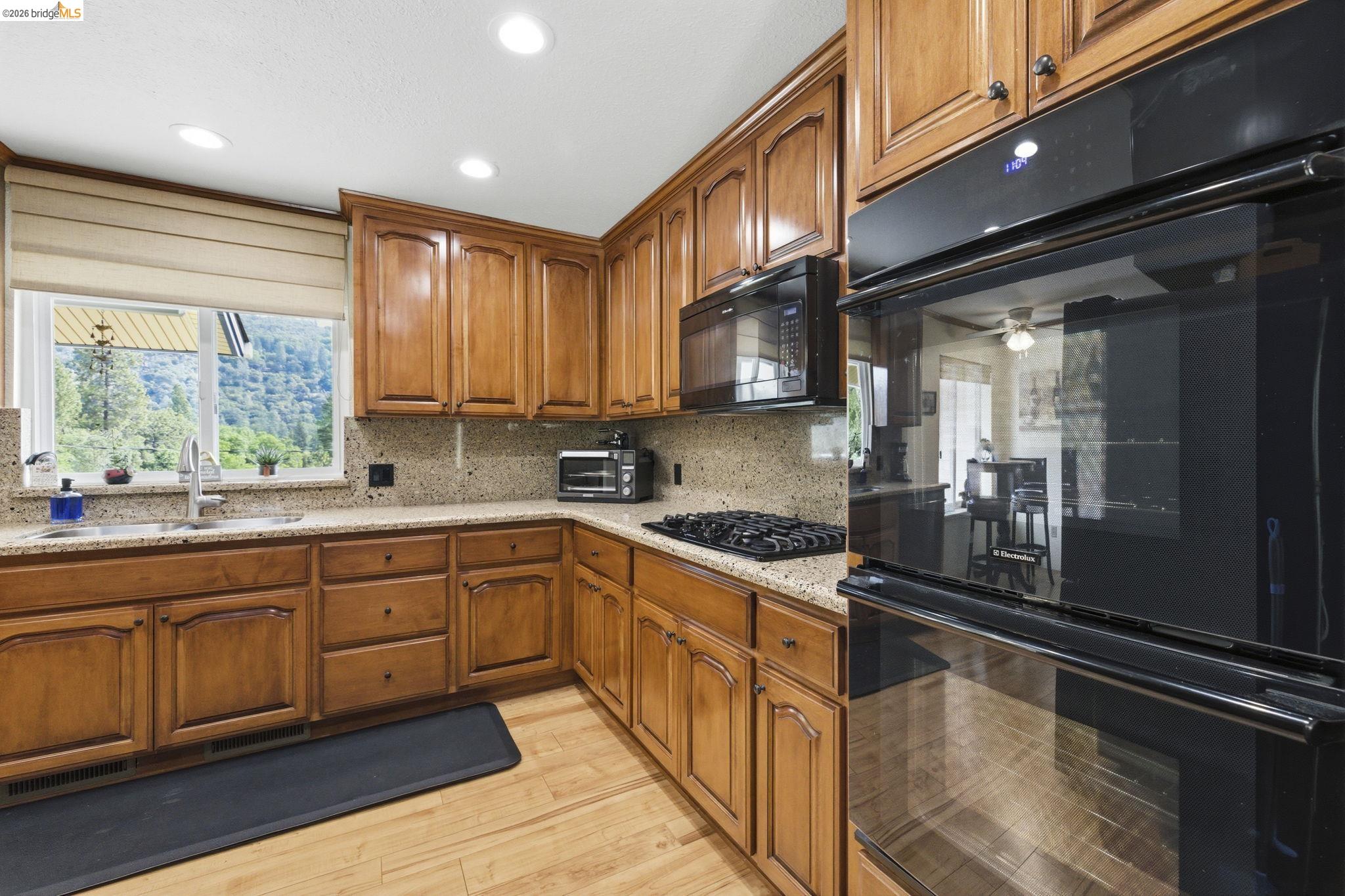 21955 Fallview Drive Sonora, CA 95370 - Photo 9 of 32 a kitchen with stainless steel appliances granite countertop a stove a sink and a microwave