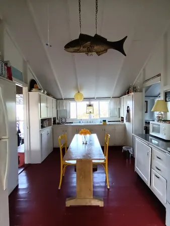 a living room with stainless steel appliances kitchen island granite countertop lots of furniture and a wooden floors