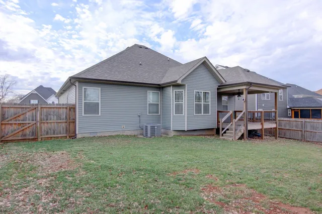 a house view with a garden space and wooden fence