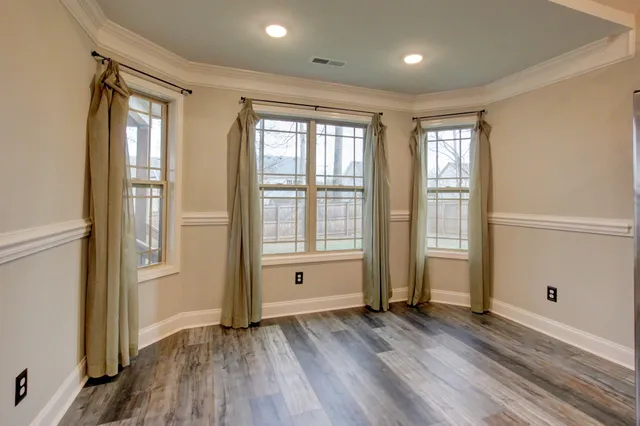 a view of an empty room and kitchen view