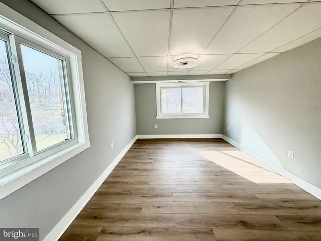 a view of empty room with wooden floor