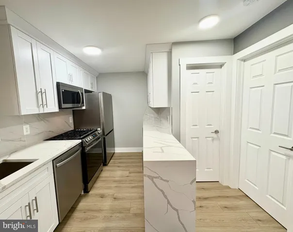 a kitchen with granite countertop cabinets stainless steel appliances and a counter space