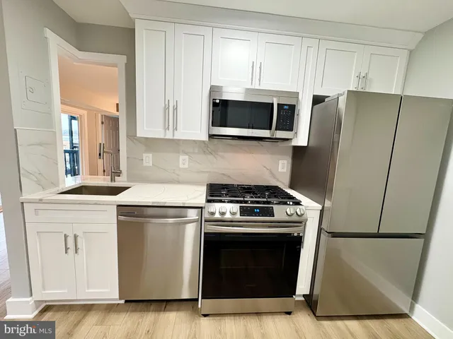 a stove top oven sitting inside of a kitchen