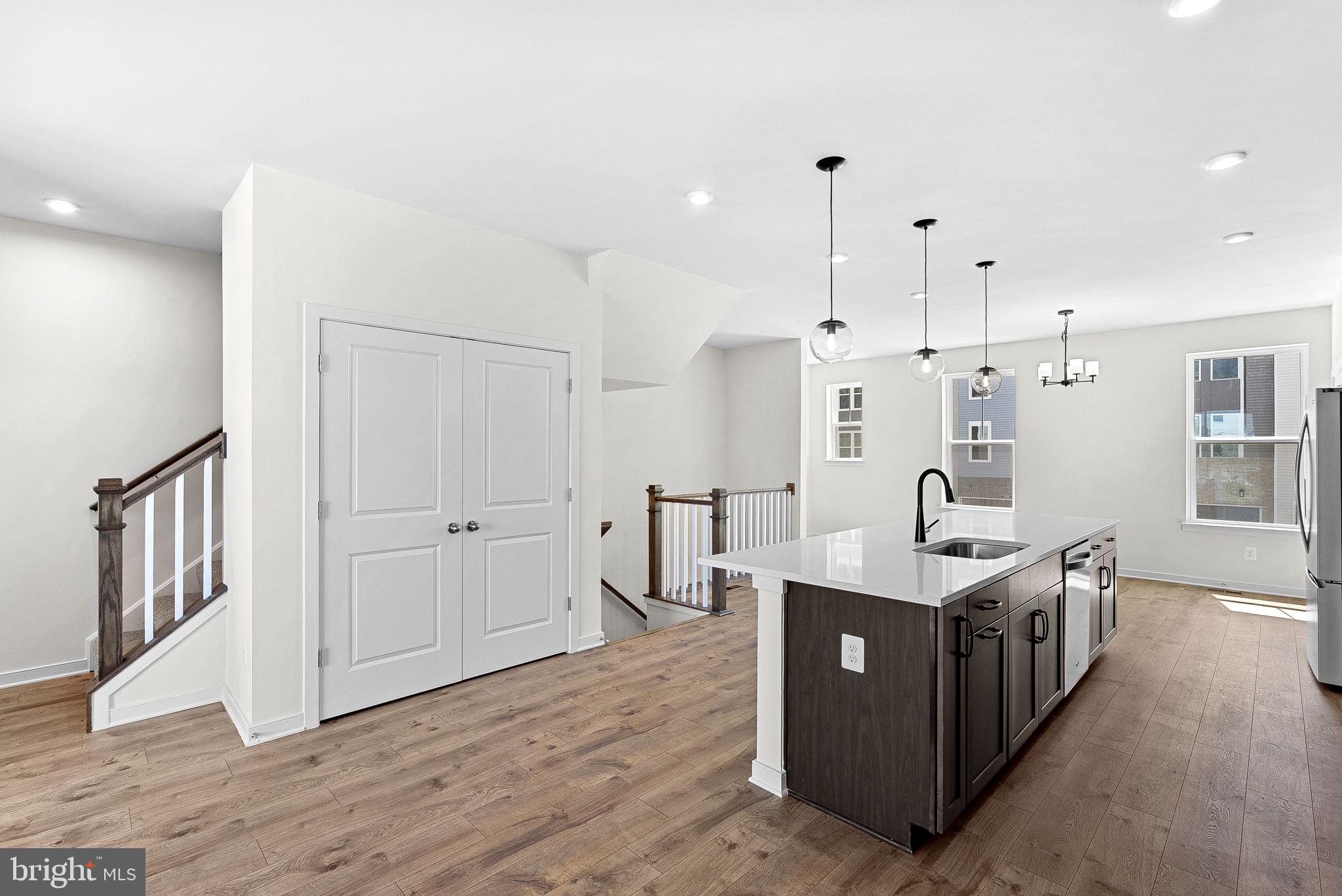 4151 Mountjoy Way Dumfries, VA 22026 - Photo 14 of 41 a large kitchen with stainless steel appliances a large counter top and wooden floors