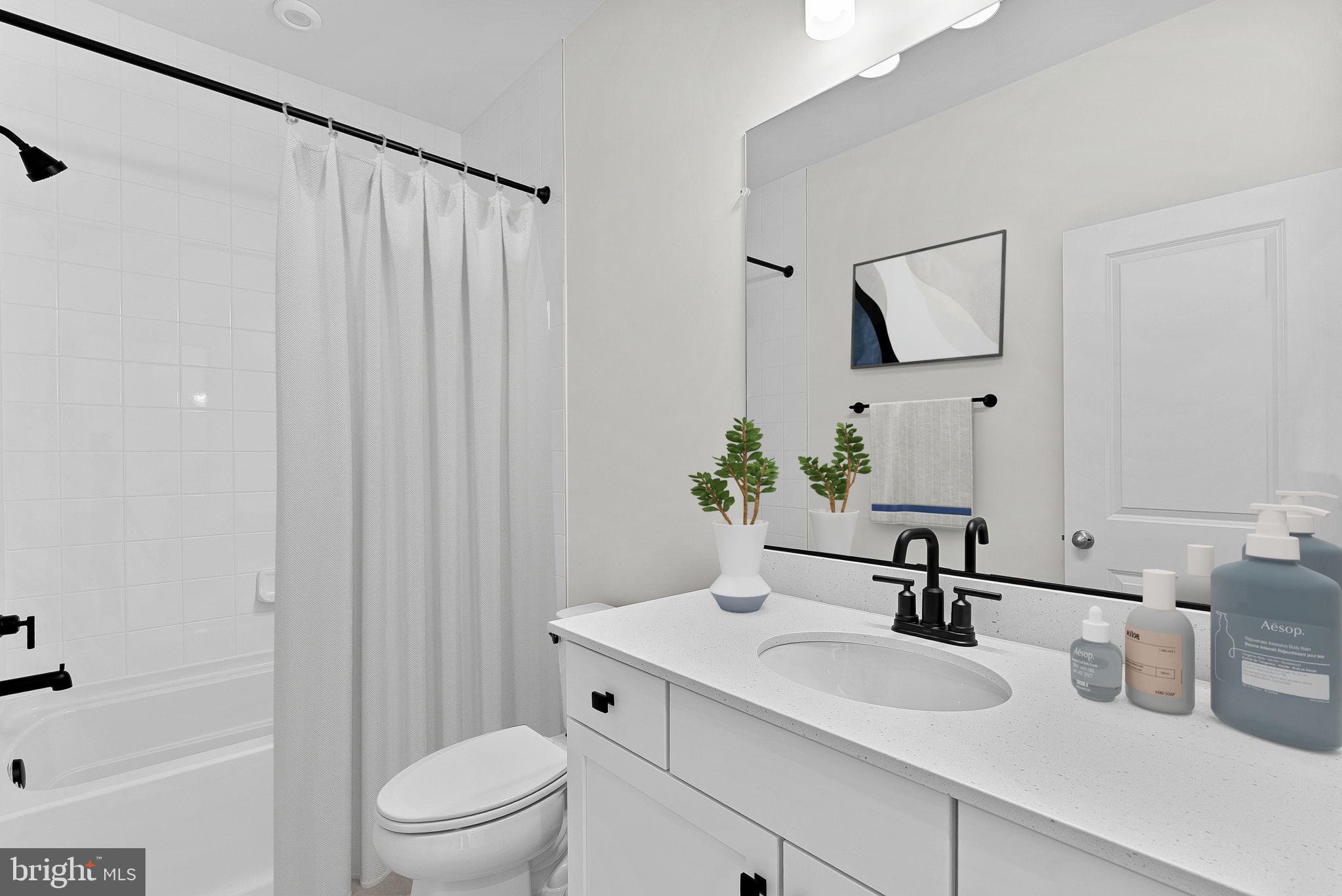 4151 Mountjoy Way Dumfries, VA 22026 - Photo 21 of 41 a bathroom with a sink a toilet and shower curtain