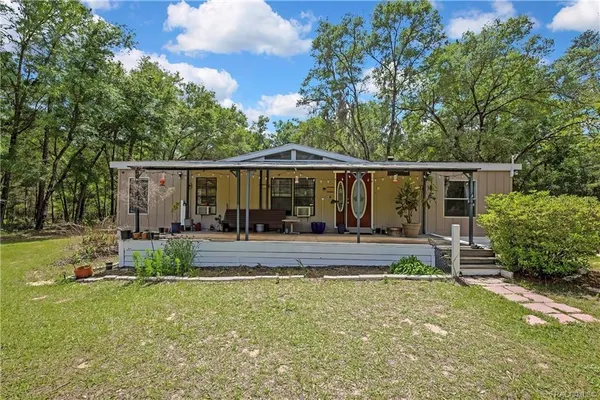 a view of a house with backyard and sitting area