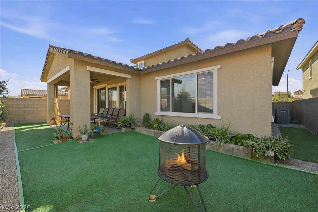 250 Dedication Avenue Henderson, NV 89011 - Photo 43 of 67 Back of property featuring a fenced backyard, a fire pit, stucco siding, a patio, and a tiled roof