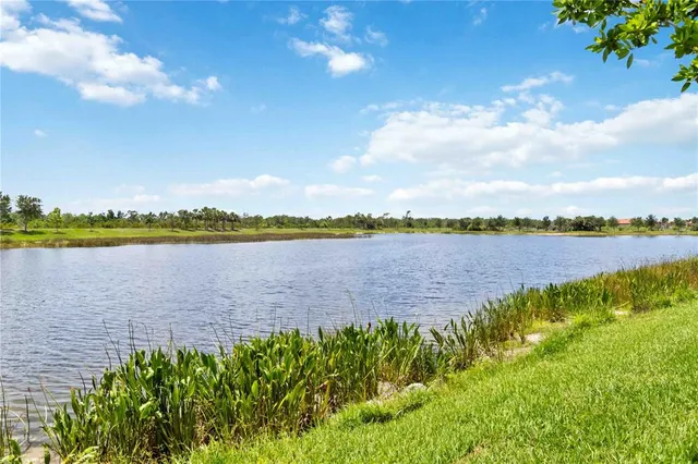 a living room with furniture a flat screen tv and kitchen view