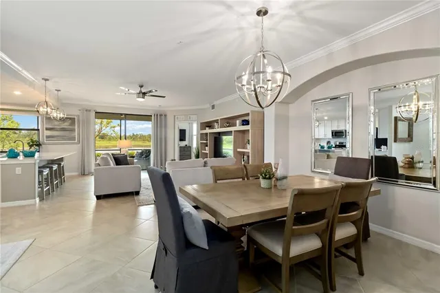 a living room with furniture a large window and a dining table