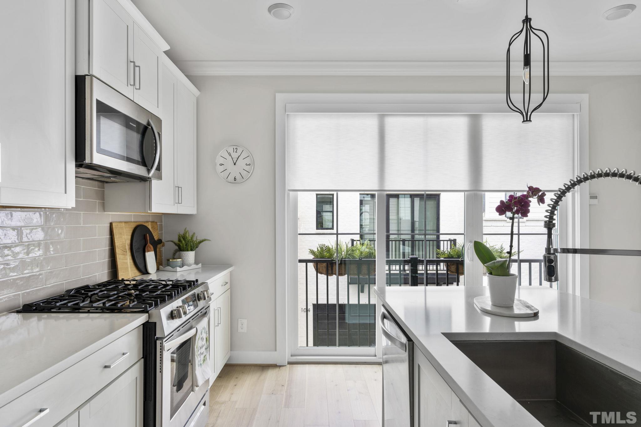 1610 Draper View Loop, Unit 104 Raleigh, NC 27608 - Photo 13 of 41 a kitchen with stainless steel appliances granite countertop a stove a sink and a microwave