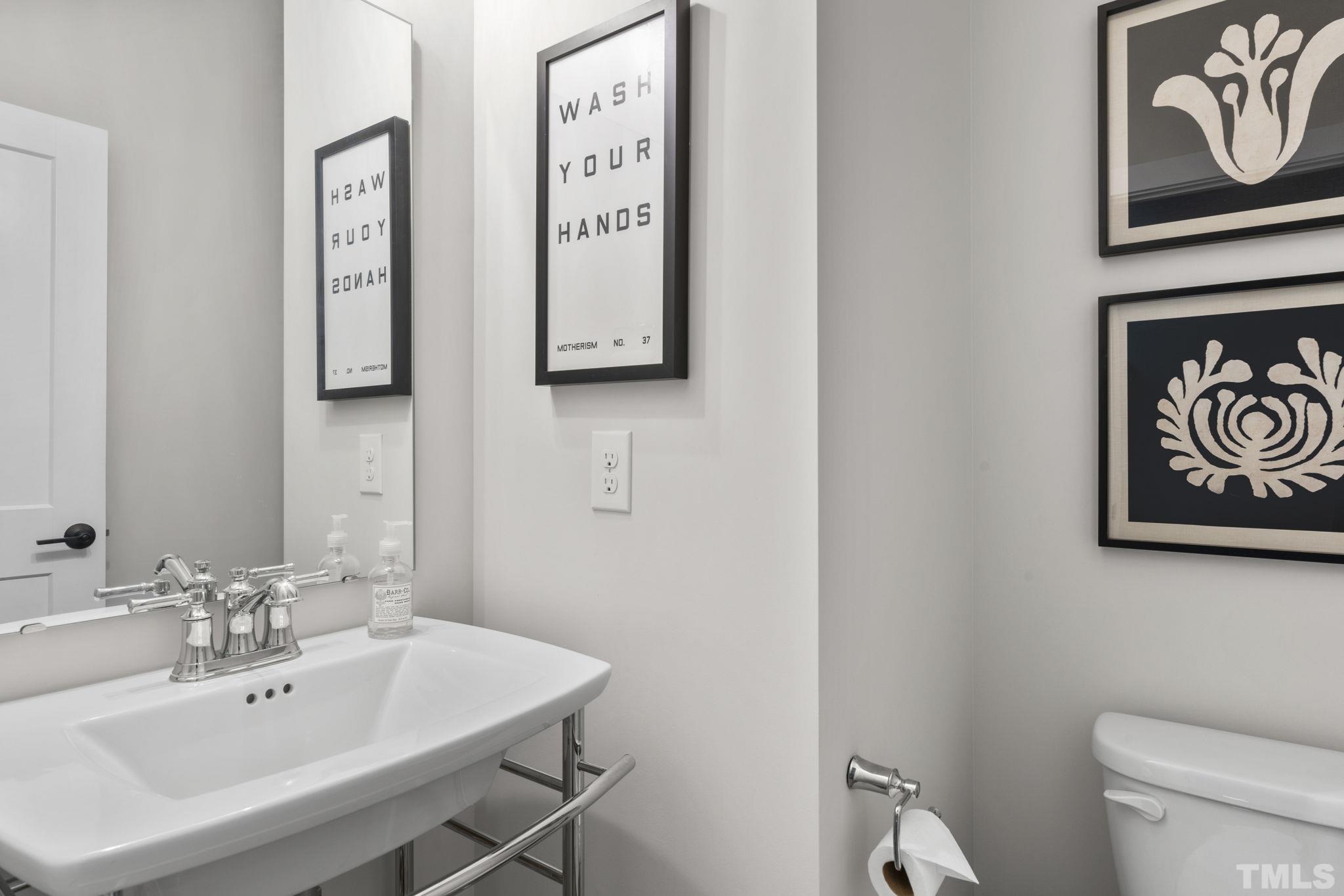 1610 Draper View Loop, Unit 104 Raleigh, NC 27608 - Photo 22 of 41 a bathroom with a toilet sink and mirror