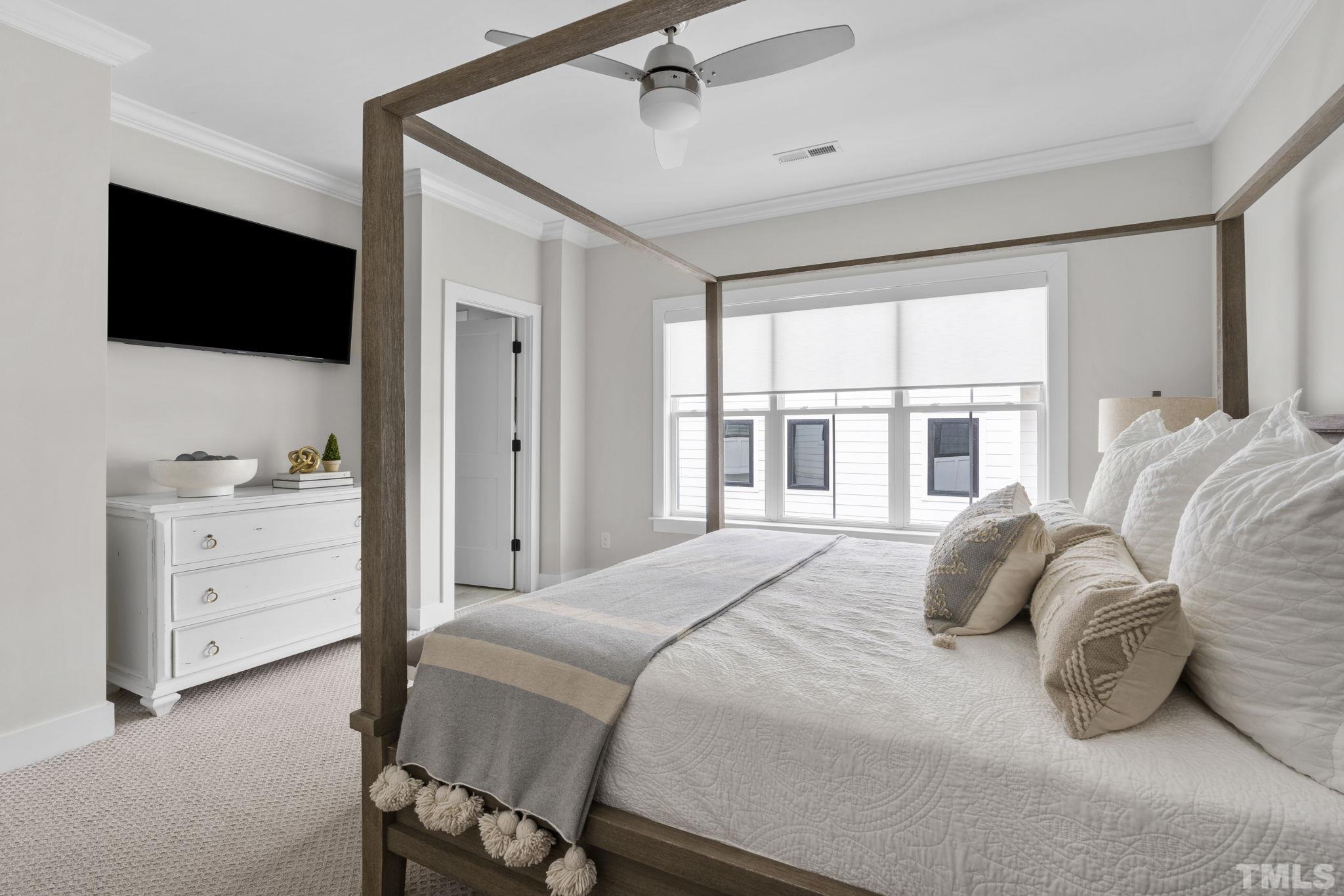 1610 Draper View Loop, Unit 104 Raleigh, NC 27608 - Photo 26 of 41 a bedroom with a bed and a flat screen tv